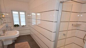 A modern bathroom with a glass shower enclosure, a sink, and a window. - Holiday home in Alkersum with swimming pool (Alkersum)