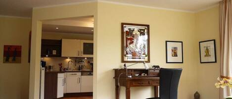 Un comedor con una mesa de madera, una silla negra y una estatua de Buda.