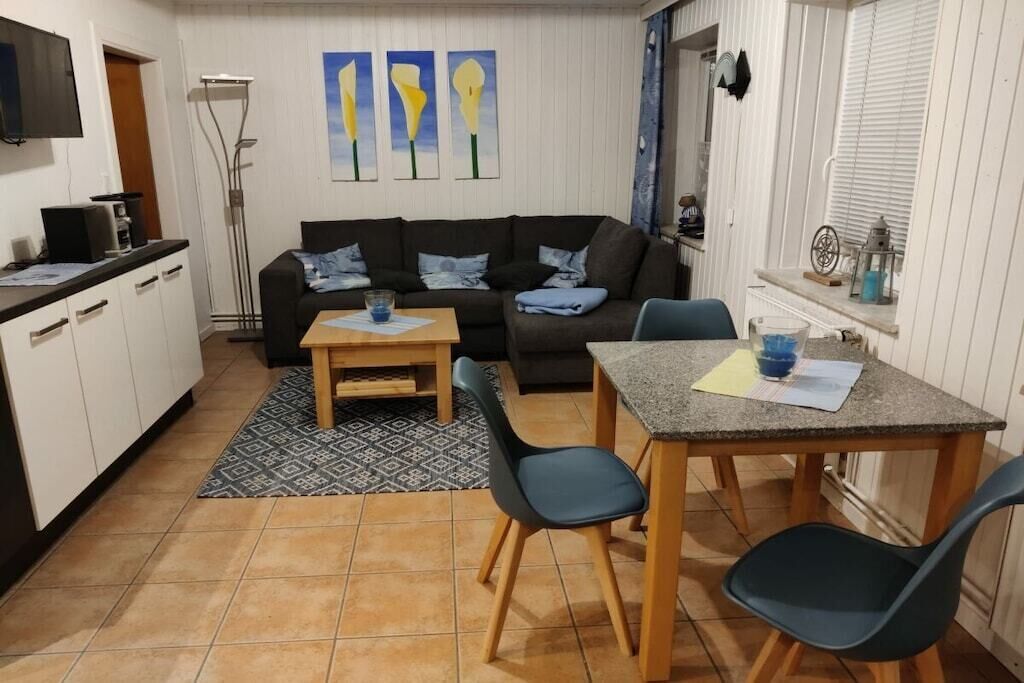 A compact living space with a sofa, a dining table, and chairs.
