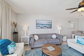 A modern living room with a grey sofa, white side tables, and a coffee table. - Phoenix V 504 by Liquid Life (Orange Beach)