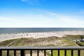 A beach with a clear sky, sandy shore, and a wooden fence in the foreground. - Phoenix V 504 by Liquid Life (Orange Beach)