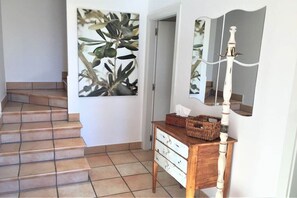 A staircase leading to a room with a wooden dresser, a mirror, and a wall-mounted light fixture. - Holiday home in Roses with swimming pool (Roses)