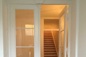 Ein Flur mit einer Holztreppe, die zu einer oberen Etage führt.