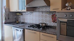 A kitchen with a gas stove, stainless steel dishwasher, and a built-in oven.