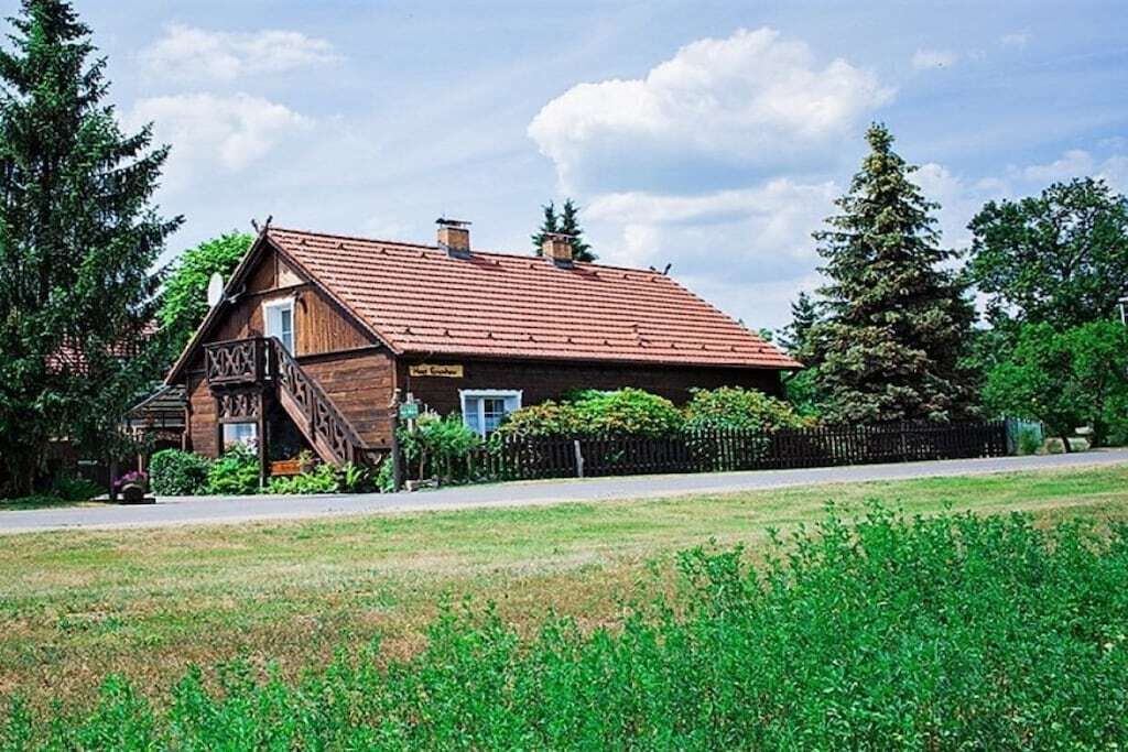 Ein Gebäude aus Holz mit rotem Dach, einer Treppe und einem Schild mit der Aufschrift 'XxX'.