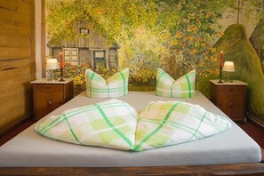 Ein Bett mit einem karierten Kopfkissen und Wandgemälde.