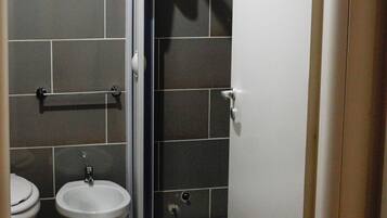 Un bagno con toilette, bidet e cabina doccia.