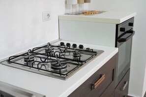 A kitchen with a gas stove, oven, and a white countertop.