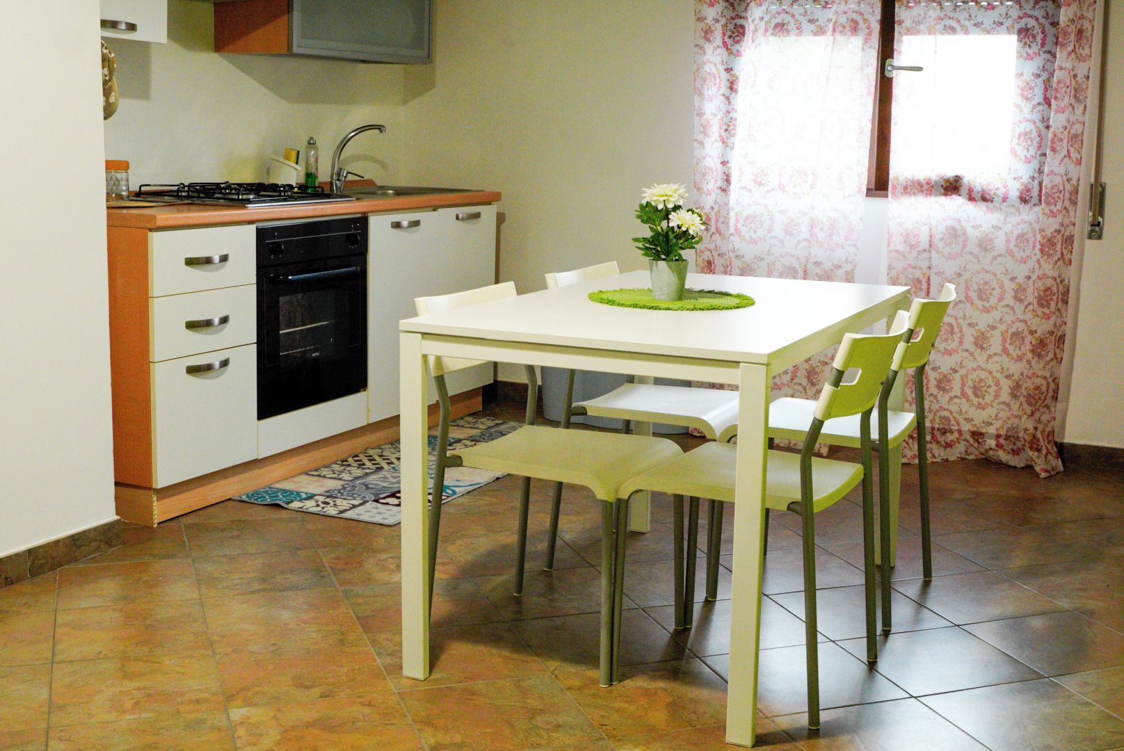 A kitchen with a white table and chairs, a stove, and a sink.