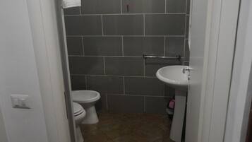 Ein Badezimmer mit Toilette, Waschbecken und Dusche.