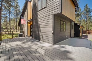 A modern wooden cabin with a deck, surrounded by trees. - Modern Tollgate Mountain Retreat (Sisters)