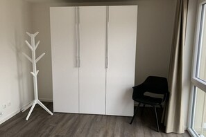 A room with a wardrobe, a chair, and a floor lamp. - Holiday home in Wangerland with sauna (Wangerland)