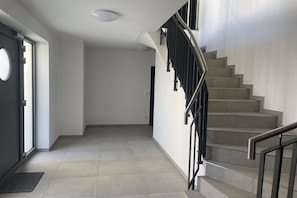 A modern interior with a staircase, a door, and a light fixture. - Apartment 1 - Strandperle (Zinnowitz)