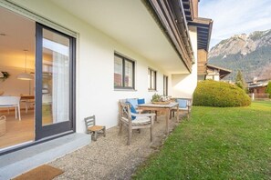 Un edificio moderno con un patio, un tavolo da pranzo e sedie.