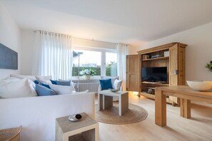 A modern living room with a sofa, coffee table, and wooden cabinet. - Holiday apartment in Oberstdorf with Wi-Fi (Oberstdorf)