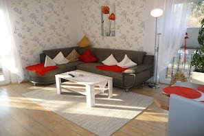 Ein Wohnzimmer mit einer Couch, einem Couchtisch und einer Stehlampe.