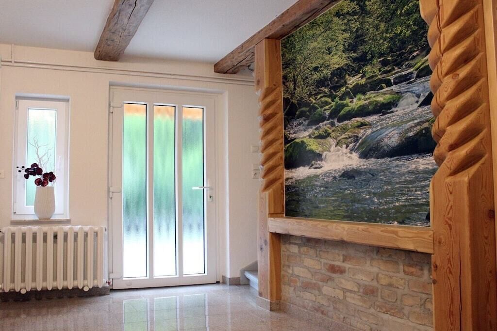 A room with a wooden-framed wall, a white radiator, and a door with frosted glass panels.