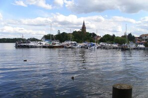 A marina with boats docked, a church spire in the background, and calm water. - Holiday home in Dambeck with swimming pool (Dambeck)