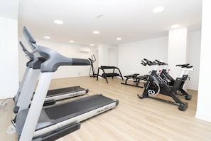 Ein Fitnessstudio mit Laufbändern, Ergometer und Kurzhanteln.