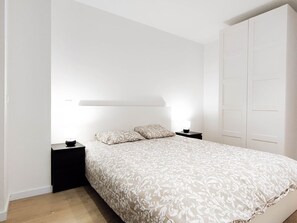 Una camera da letto con un letto, comodini, un tavolino e un armadio.