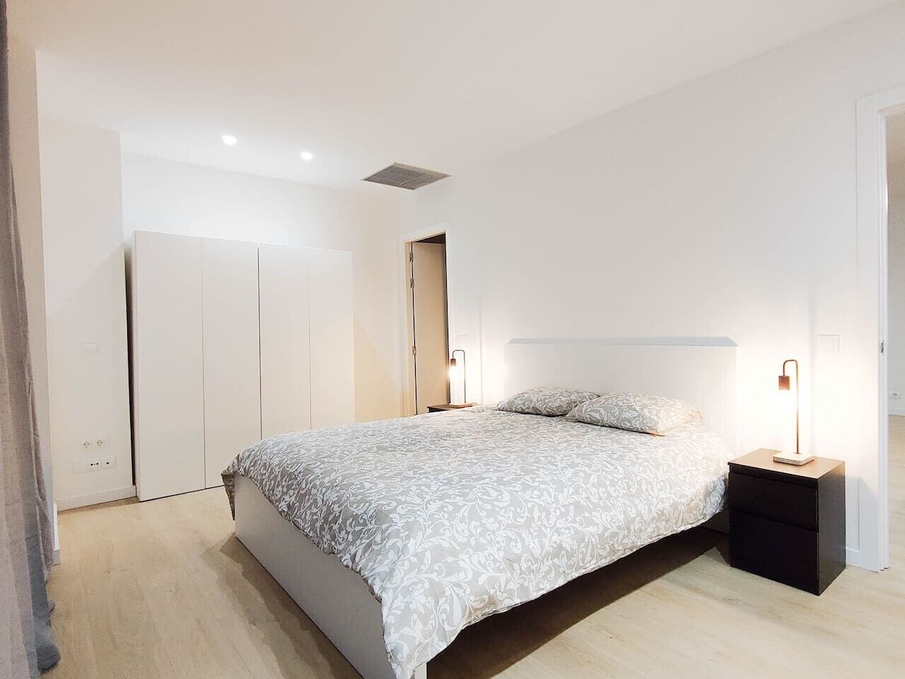 Ein Schlafzimmer mit einem Bett, Nachttischen und einem Kleiderschrank.