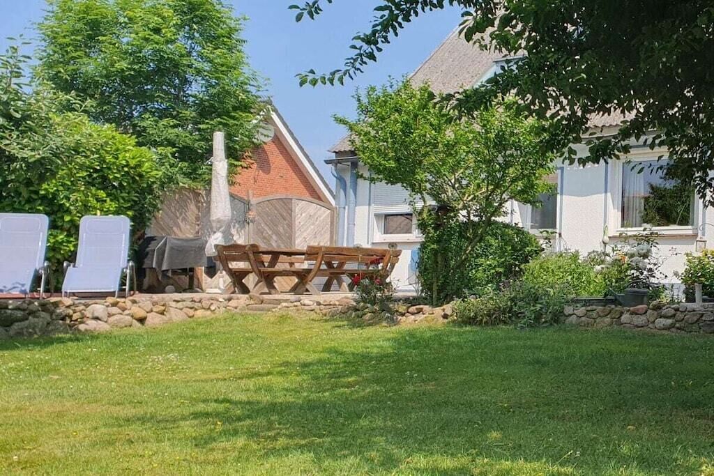 Ein Gartenbereich mit Picknicktisch und einer Steinmauer.