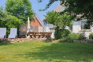 Ein Gartenbereich mit Picknicktisch und einer Steinmauer.