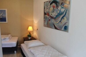 Une chambre à coucher avec un lit, une table de chevet avec une lampe et un tableau au mur.