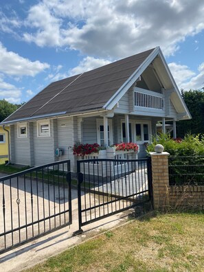 A two-story house with a front porch, a garage, and a fenced driveway. - Holiday Home 'Haus Der Sinne' with Private Terrace and Wi-Fi (Wolgast)