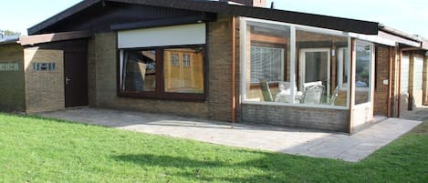 A modern building with a garage door, large windows, and a brick facade.