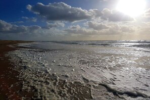 Une plage avec des vagues et un ciel dégagé.