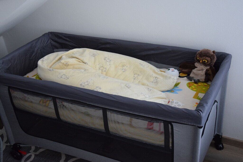 Een ruimtje om te slapen, met een matras, deken, knuffel en een opbergmand van gaas.