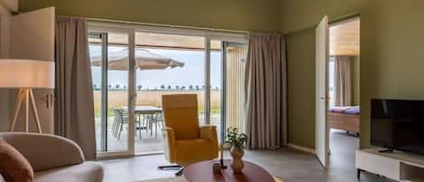 Un salon moderne avec un canapé, un fauteuil et un meuble pour la télévision.