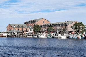 A waterfront building with multiple balconies and a dock with several boats. - Holiday apartment with 1 bedroom (Heiligenhafen)