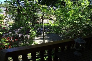 Ein Garten mit einem Kiesweg, einer Holzterrasse und einer Laterne.