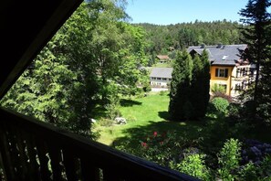 Ett bostadsområde med hus, en välskött gräsmatta och tät vegetation.