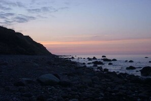 A rocky beach with a cliff on the left and calm sea. - Holiday apartment with 2 bedrooms (Boltenhagen)