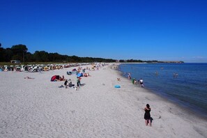 A beach with people sunbathing and swimming, tents, and a clear sky. - Holiday apartment with 2 bedrooms (Boltenhagen)