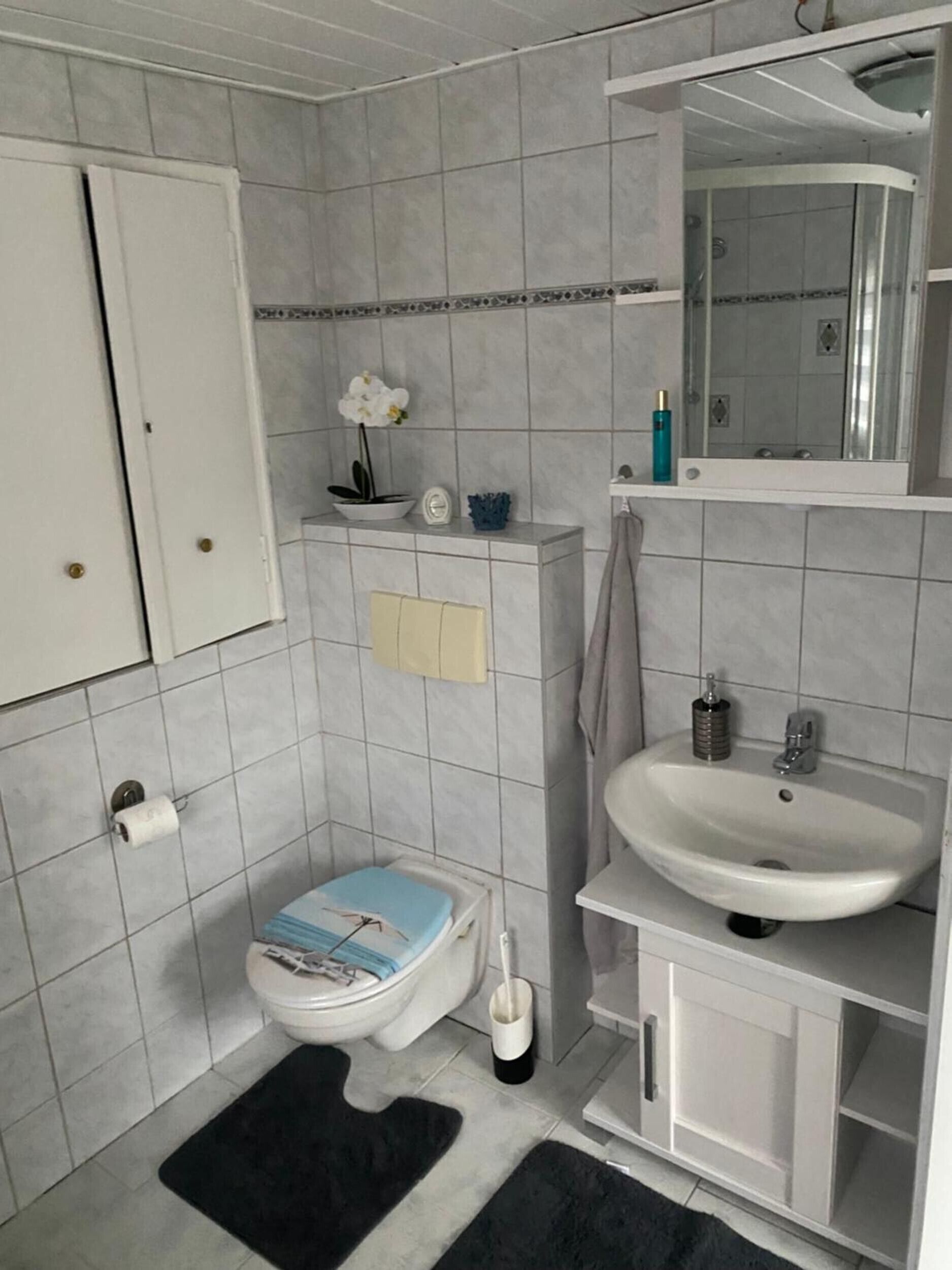 Un baño pequeño con inodoro, lavabo y espejo.