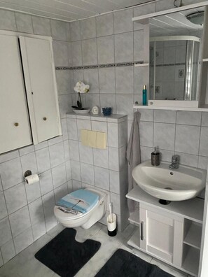 Un baño pequeño con inodoro, lavabo y espejo.