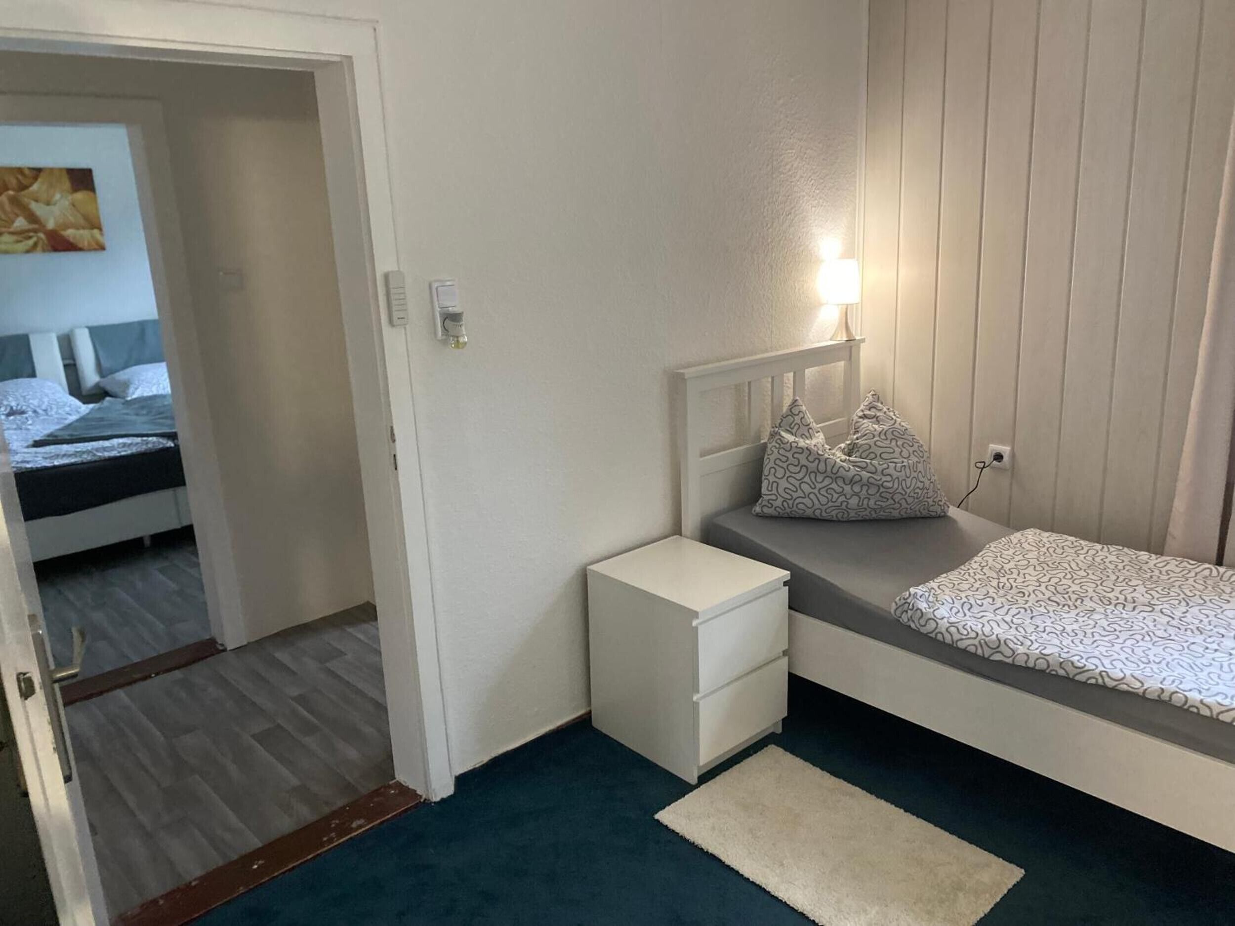 Een slaapkamer met een bed, nachtkastje en bedtafel.