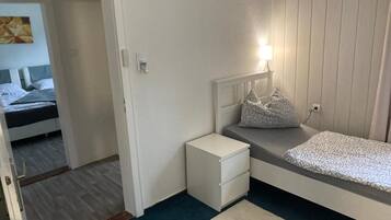 Een slaapkamer met een bed, nachtkastje en bedtafel.