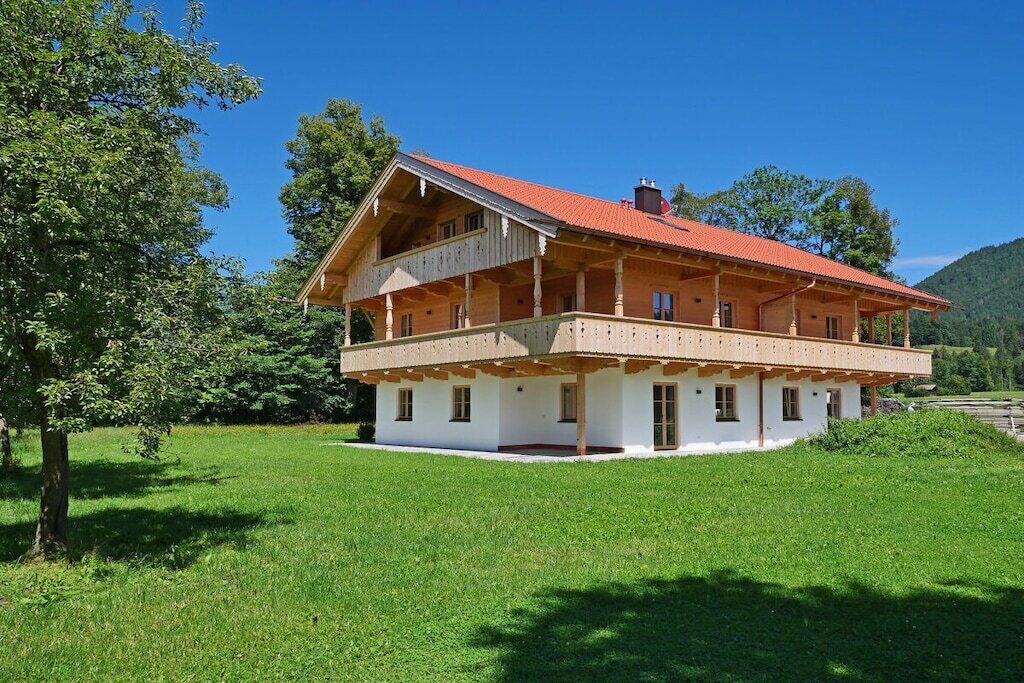 A two-story building with a red roof, white walls, and a balcony.