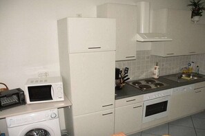 Une cuisine compacte équipée d’un four à micro-ondes, d’un grille-pain et d’un four traditionnel.