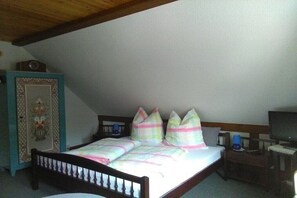 Ein Schlafzimmer mit einem Einzelbett, einem Nachttisch, einem Fernseher und einer Kommode.