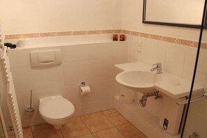 Ein Badezimmer mit Toilette, Waschbecken und Duschbereich.