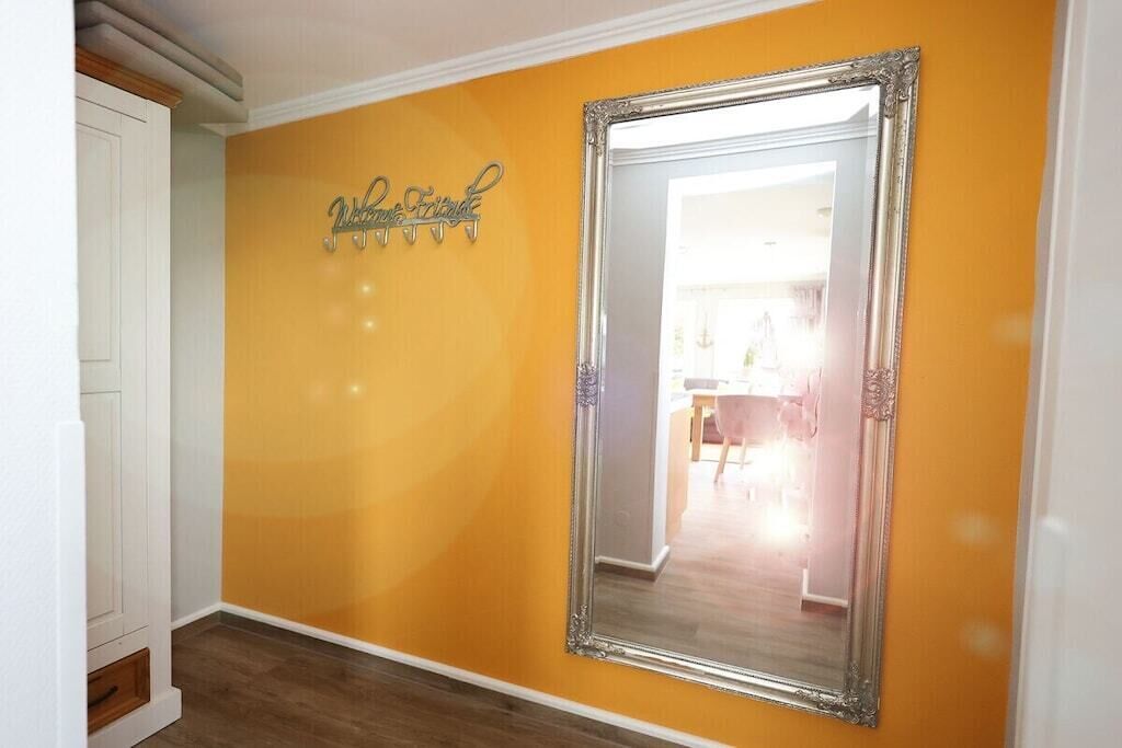 Un pasillo con un espejo grande y un cartel en la pared.