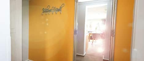 A hallway with a large mirror and a sign on the wall.