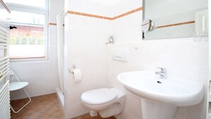 Bany amb vàter, rentamig i dutxa. Hi ha una finestra que deixa entrar llum natural.