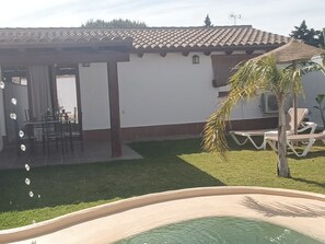 A residential property with a swimming pool, a covered patio, and a lawn. - Villa Margarita    . (Chiclana de la Frontera)